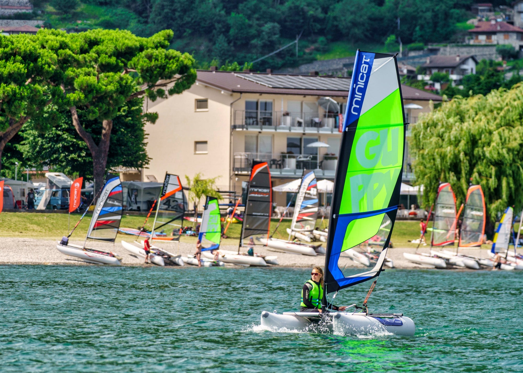 MiniCat GUPPY small catamaran sailing during regatta at the lake Como in Italy